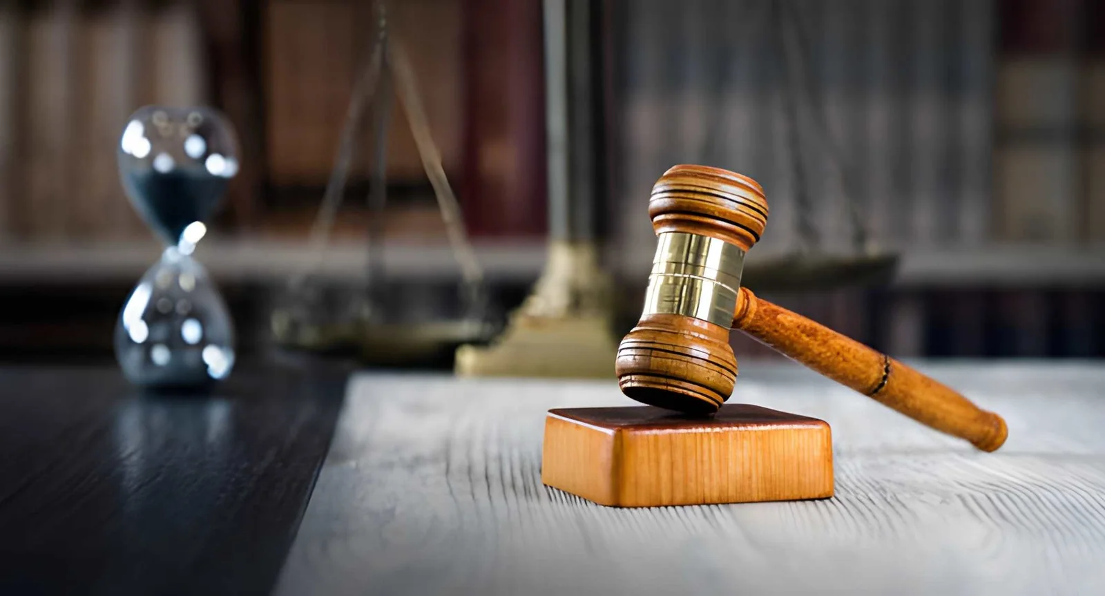 木制法槌、司法天平与沙漏，象征刑事法院程序与案件时间