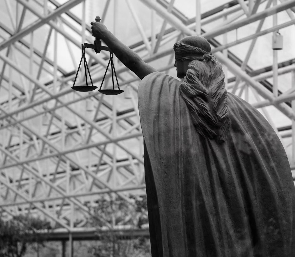黑白司法女神雕像手持天平，象征刑事法律与正义